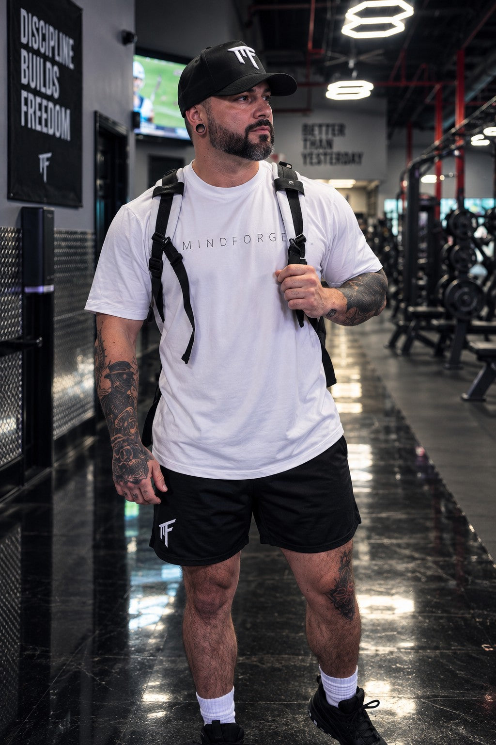 Coach Shred wearing the MindForge Essential Tee, MF shorts, and MF snapback in the gym